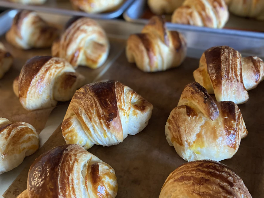 Trays of freshly baked croissants cooling on the counter